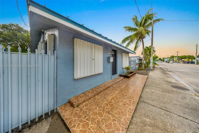 a view of the patio with chairs and table under an umbrella