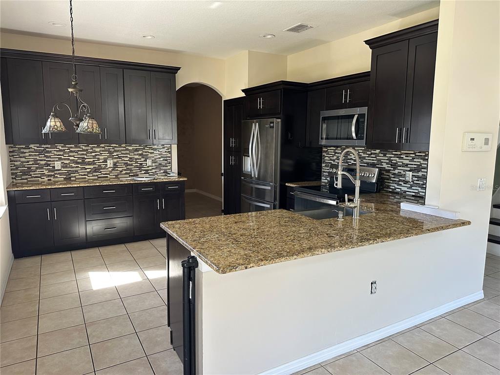 4150 Vanern Way Kissimmee, FL 34746 - Photo 8 of 51 a kitchen with stainless steel appliances granite countertop a sink and a stove