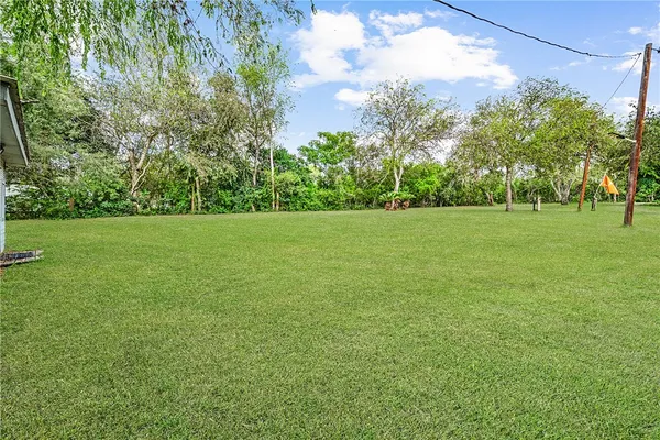 a view of a field with trees in the background