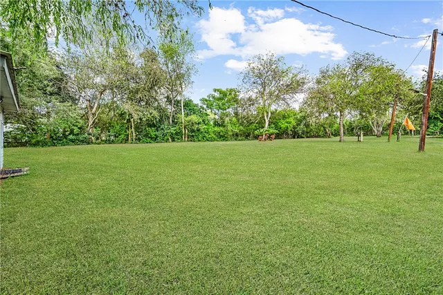 a view of a field with trees in the background