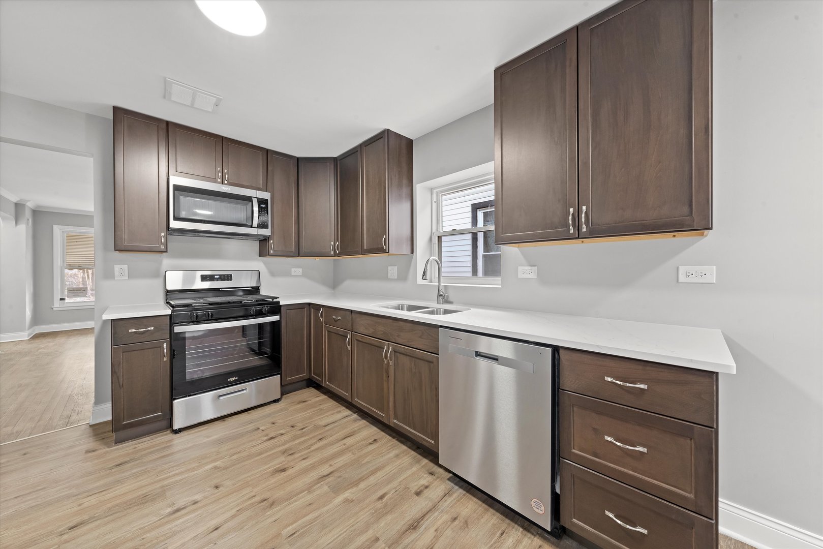 10344 South State Street Chicago, IL 60628 - Photo 11 of 30 a kitchen with granite countertop wooden cabinets and stainless steel appliances