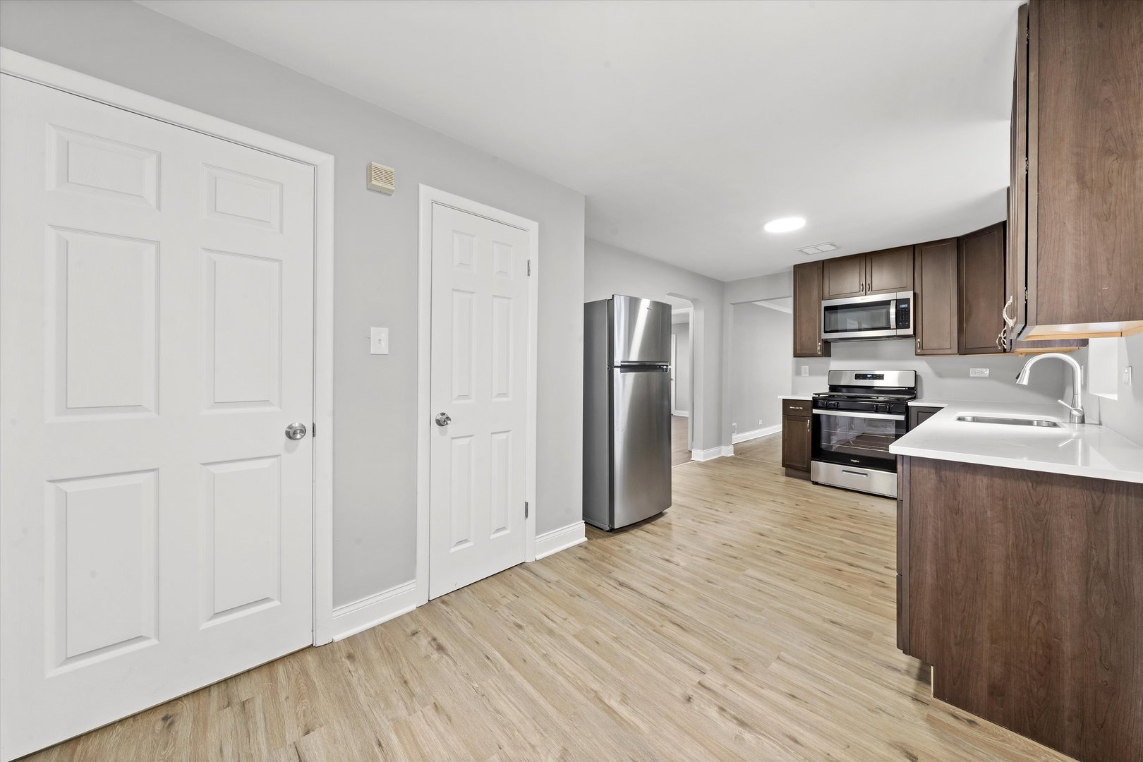 10344 South State Street Chicago, IL 60628 - Photo 12 of 30 a kitchen with stainless steel appliances granite countertop a refrigerator oven a sink with wooden cabinets and wooden floor