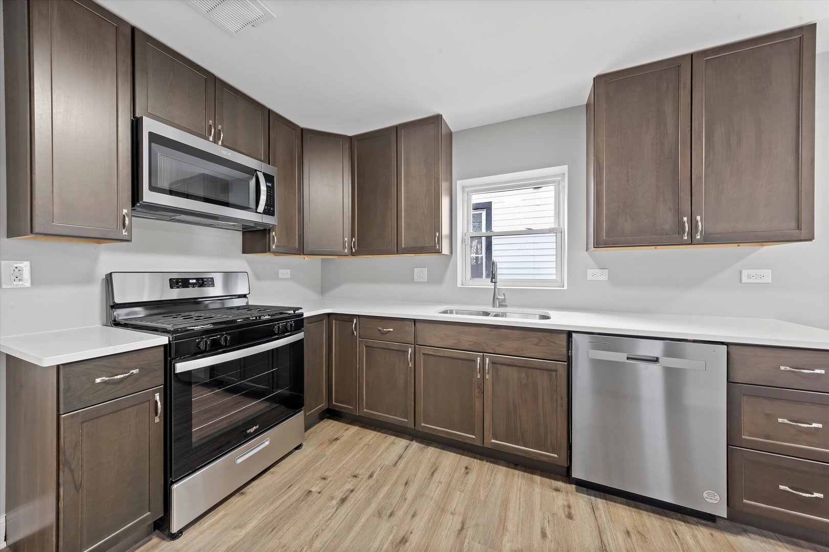 10344 South State Street Chicago, IL 60628 - Photo 13 of 30 a kitchen with stainless steel appliances granite countertop a stove a sink and a microwave