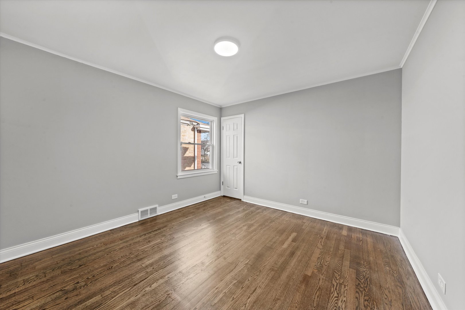 10344 South State Street Chicago, IL 60628 - Photo 27 of 30 a view of an empty room with wooden floor and a window