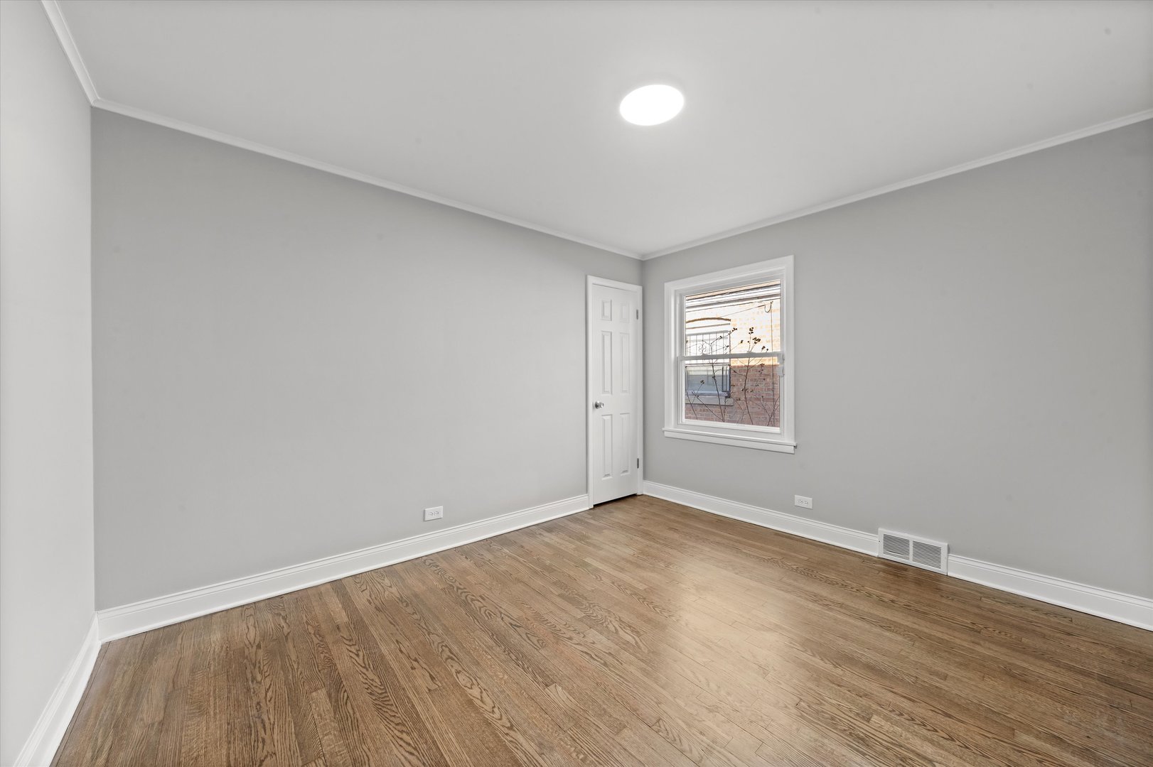 10344 South State Street Chicago, IL 60628 - Photo 7 of 30 a view of an empty room with wooden floor and a window