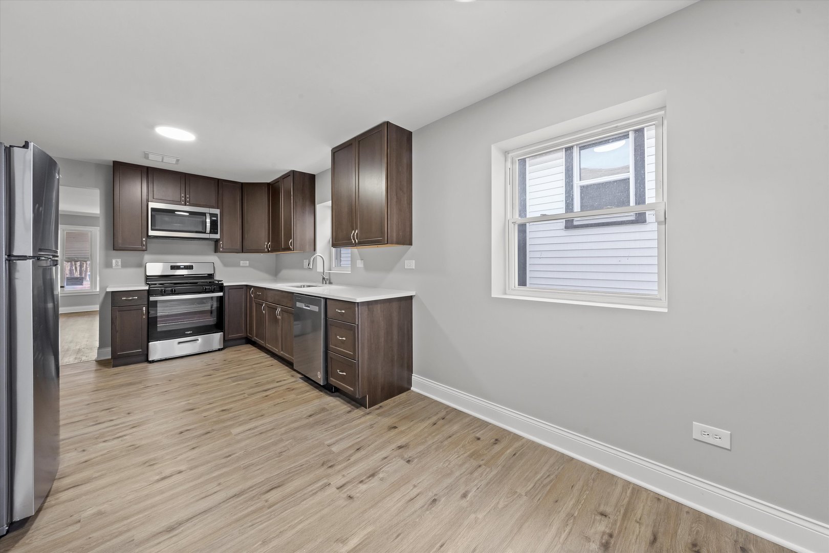 10344 South State Street Chicago, IL 60628 - Photo 9 of 30 a kitchen with stainless steel appliances granite countertop a sink cabinets and wooden floor