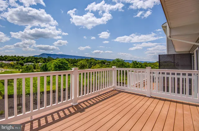 a kitchen with stainless steel appliances granite countertop a refrigerator a sink dishwasher a stove top oven a refrigerator and white cabinets with wooden floor