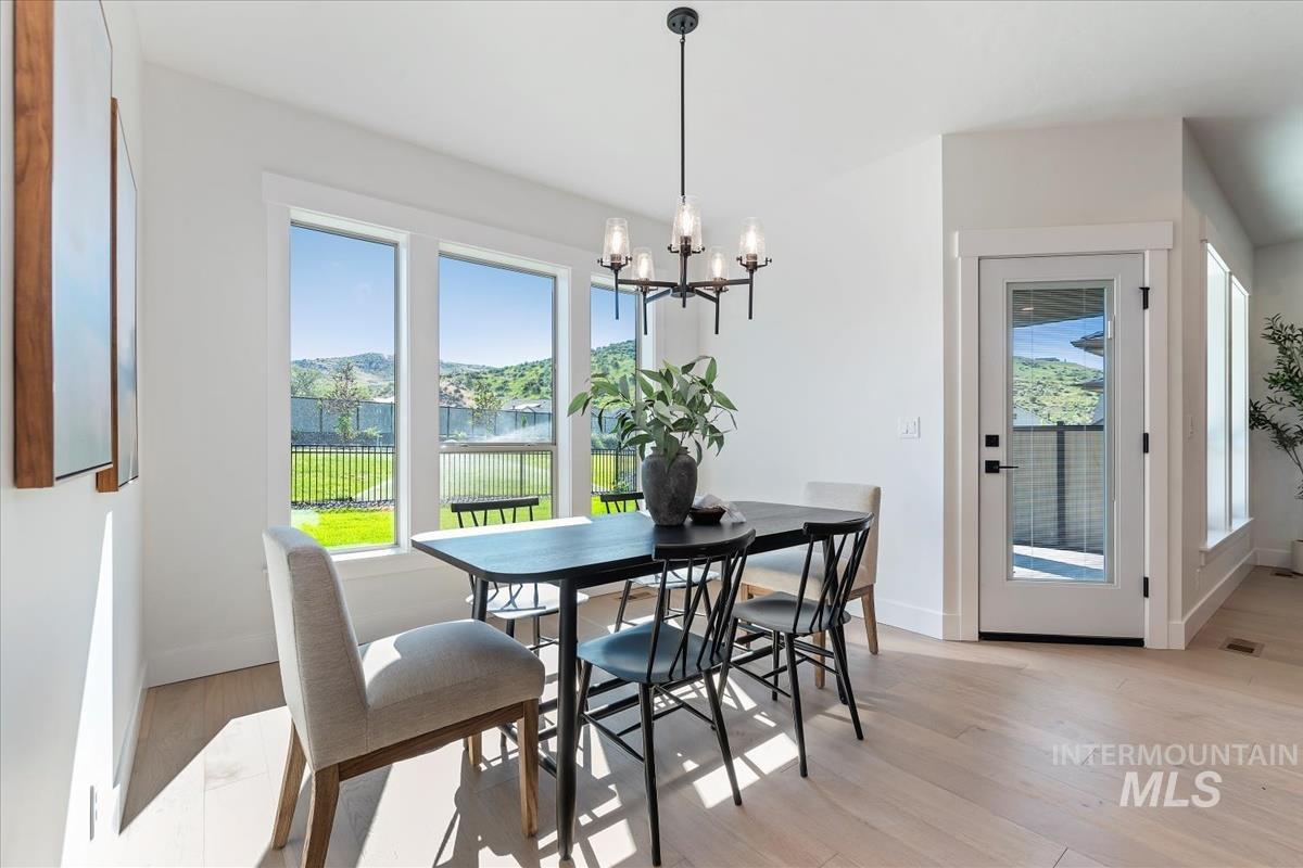2242 East Rodeo Street Kuna, ID 83634 - Photo 11 of 37 Dining space featuring light wood-style flooring, a water view, and a chandelier