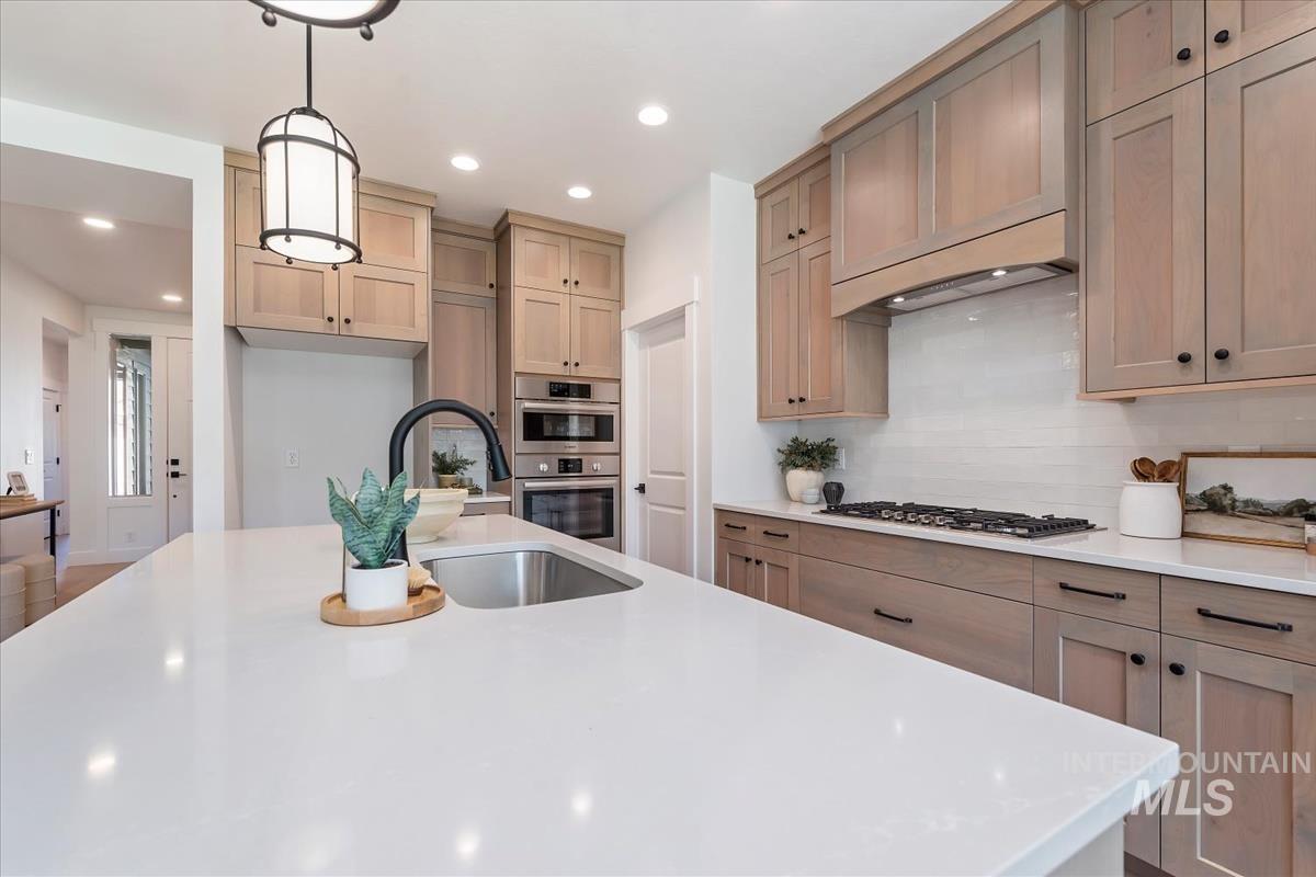 2242 East Rodeo Street Kuna, ID 83634 - Photo 13 of 37 Kitchen featuring hanging light fixtures, recessed lighting, light stone counters, stainless steel appliances, and tasteful backsplash