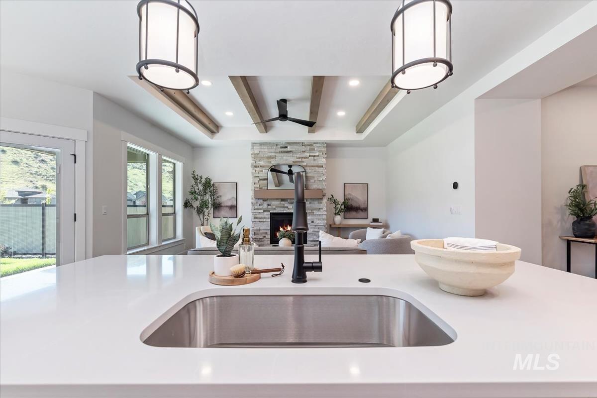 2242 East Rodeo Street Kuna, ID 83634 - Photo 37 of 37 Kitchen with hanging light fixtures, a fireplace, light stone counters, open floor plan, and ceiling fan