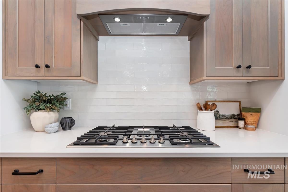 2242 East Rodeo Street Kuna, ID 83634 - Photo 14 of 37 Kitchen featuring range hood, stainless steel gas cooktop, and decorative backsplash