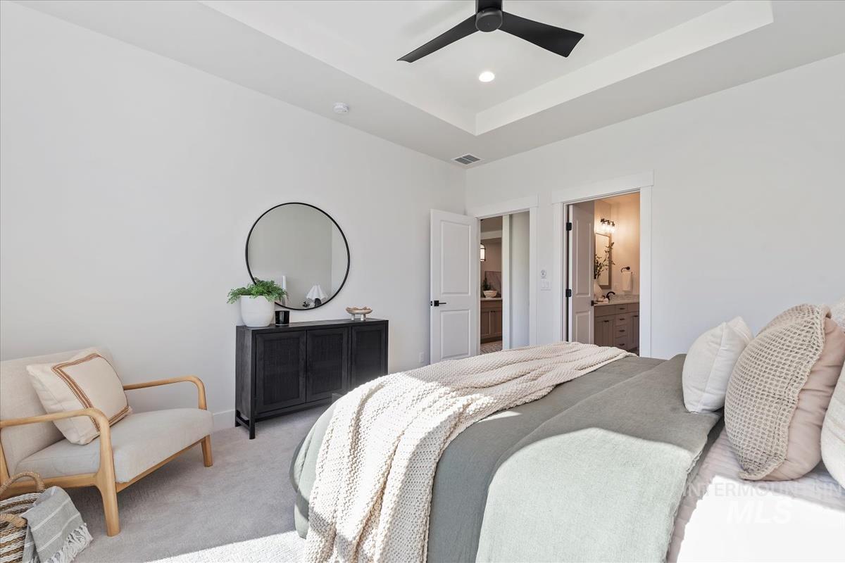 2242 East Rodeo Street Kuna, ID 83634 - Photo 26 of 37 Carpeted bedroom with a raised ceiling, connected bathroom, ceiling fan, and recessed lighting