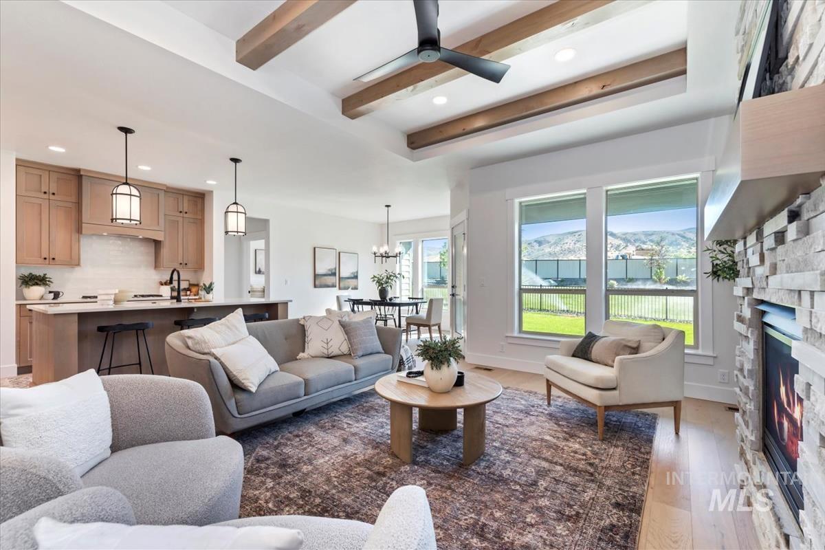 2242 East Rodeo Street Kuna, ID 83634 - Photo 6 of 37 Living room featuring recessed lighting, a stone fireplace, wood finished floors, beamed ceiling, and ceiling fan