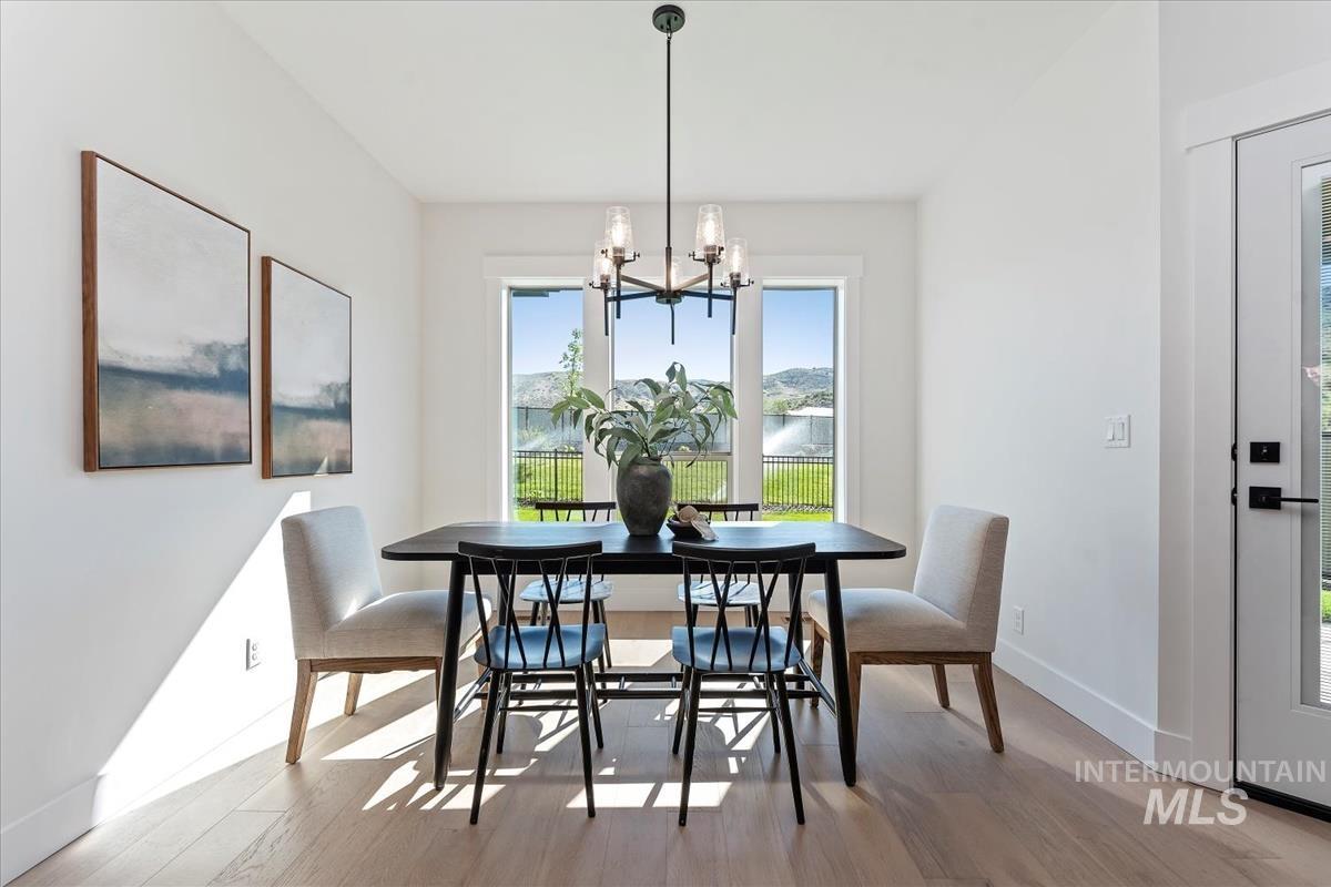 2242 East Rodeo Street Kuna, ID 83634 - Photo 10 of 37 Dining area featuring healthy amount of natural light, light wood finished floors, a chandelier, and a water view