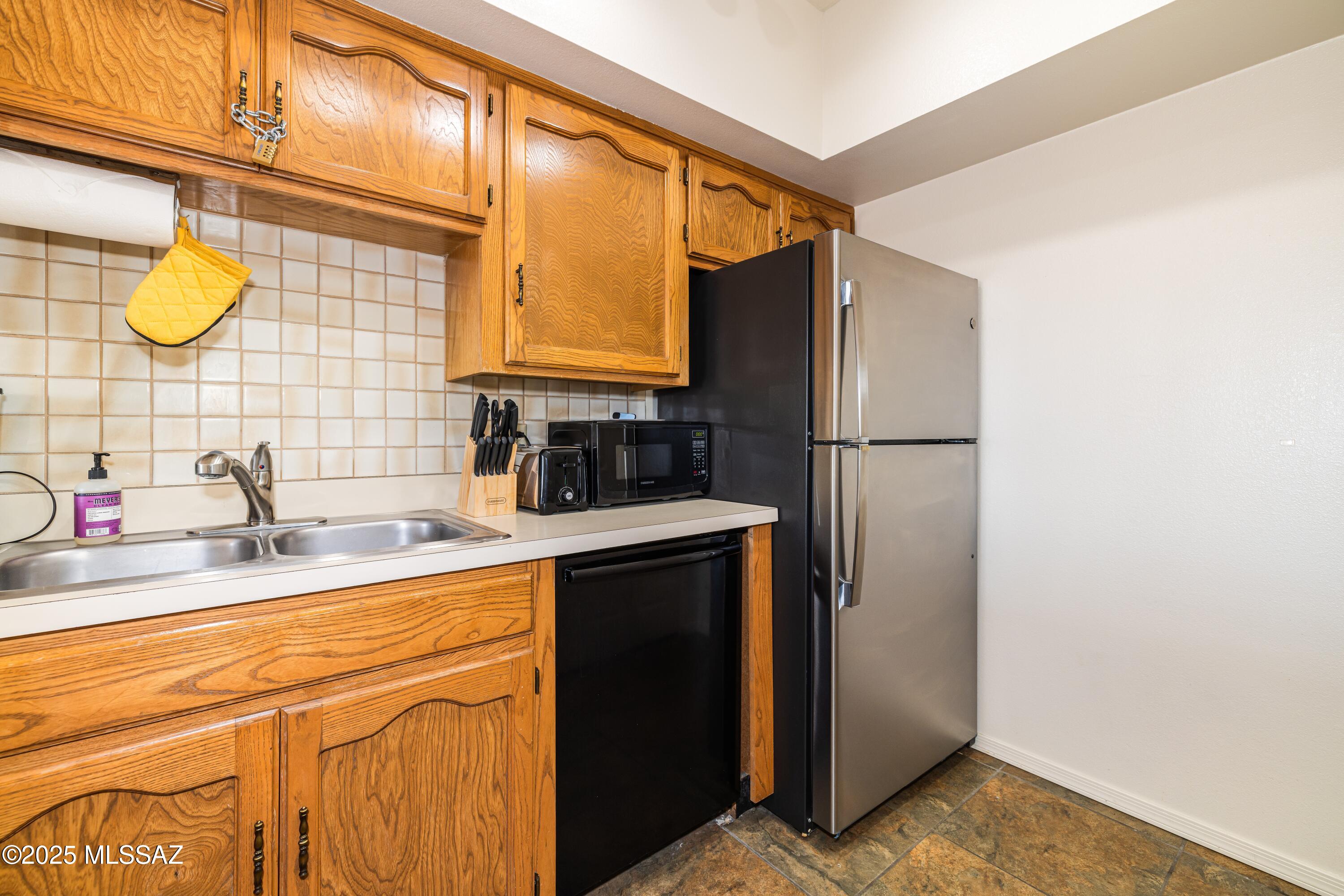 1200 East River Road, Unit G88 Tucson, AZ 85718 - Photo 5 of 13 a kitchen with stainless steel appliances granite countertop a sink and a refrigerator