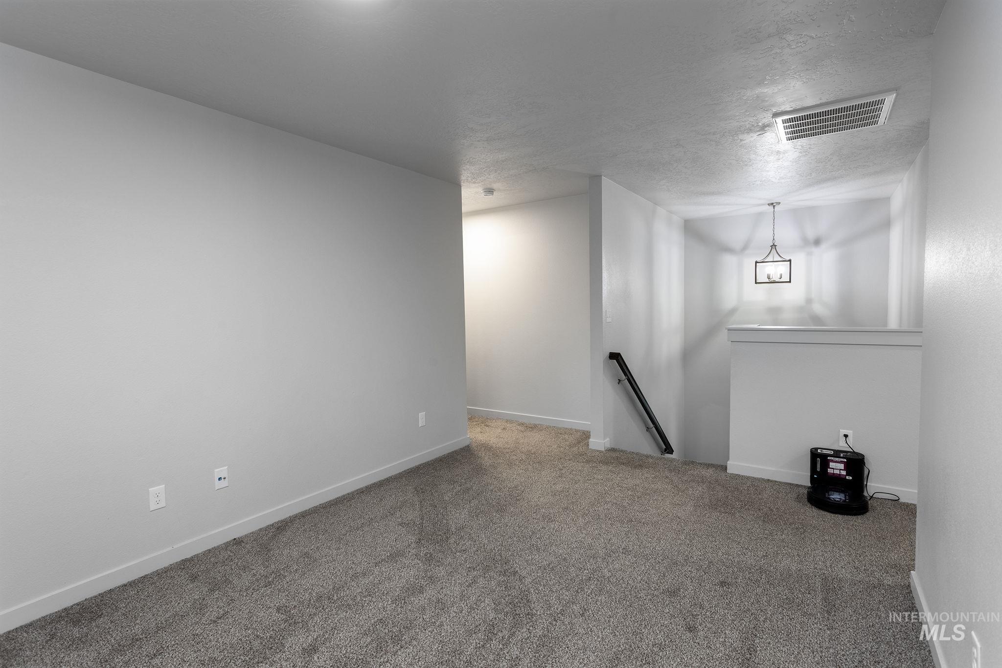 262 South Riggs Spg Avenue Meridian, ID 83642 - Photo 10 of 25 Carpeted empty room featuring a textured ceiling and baseboards