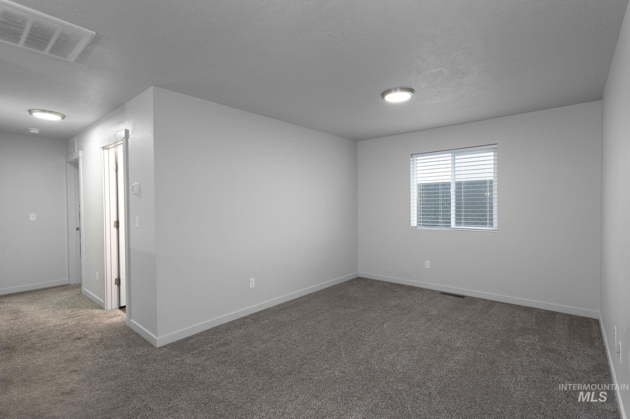 262 South Riggs Spg Avenue Meridian, ID 83642 - Photo 11 of 25 Carpeted spare room featuring a textured ceiling