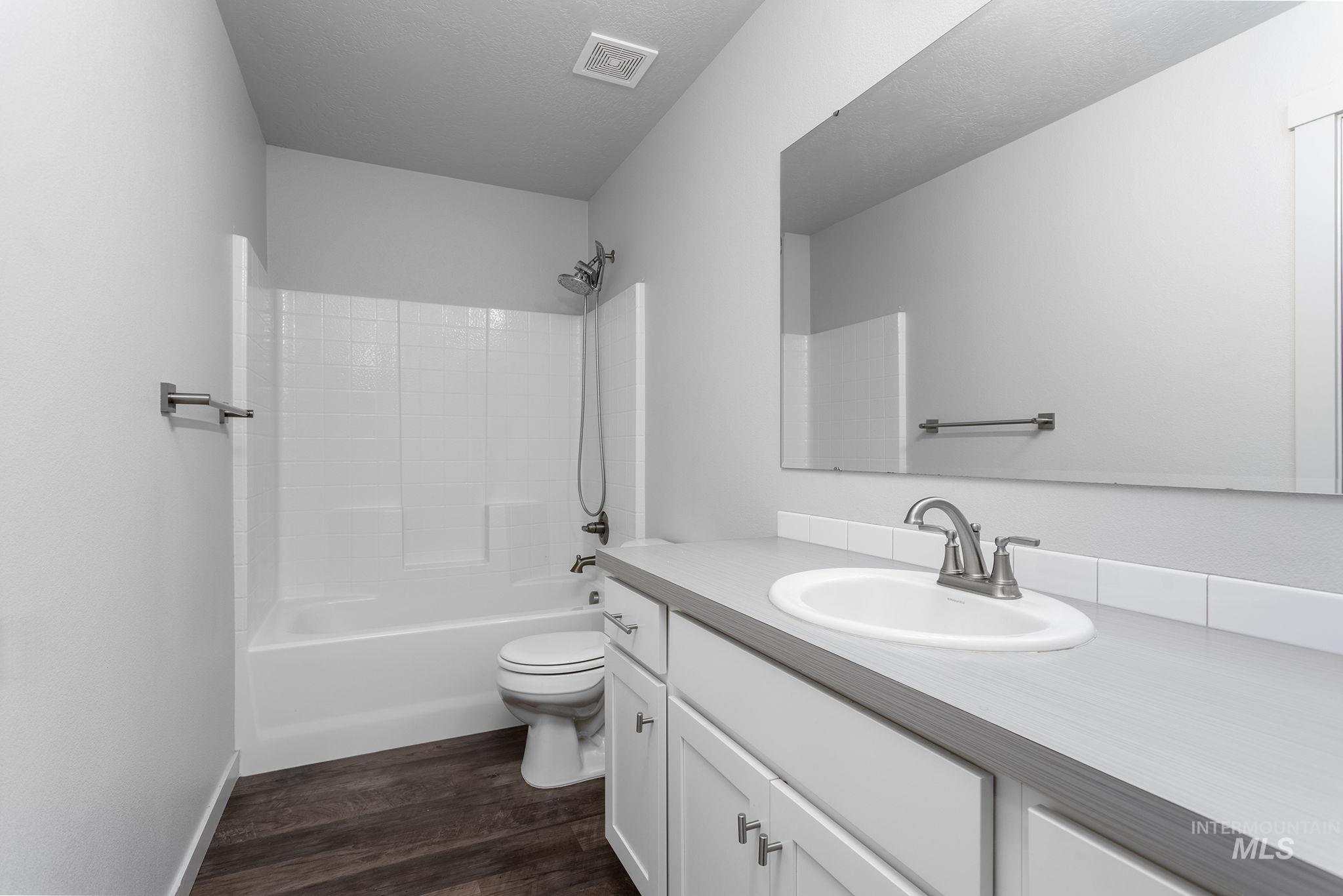 262 South Riggs Spg Avenue Meridian, ID 83642 - Photo 12 of 25 Full bathroom with vanity, tub / shower combination, and dark wood finished floors