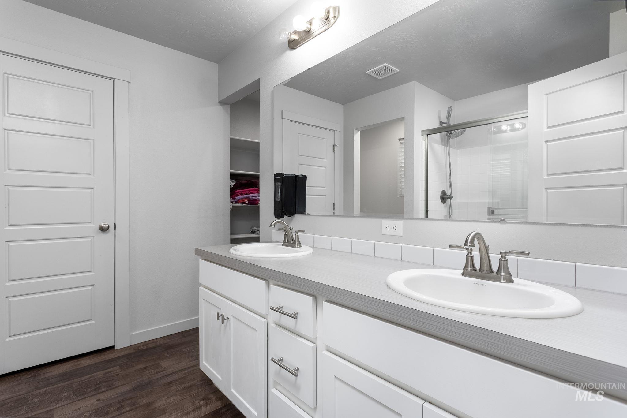 262 South Riggs Spg Avenue Meridian, ID 83642 - Photo 20 of 25 Bathroom with double vanity, a shower stall, and dark wood finished floors