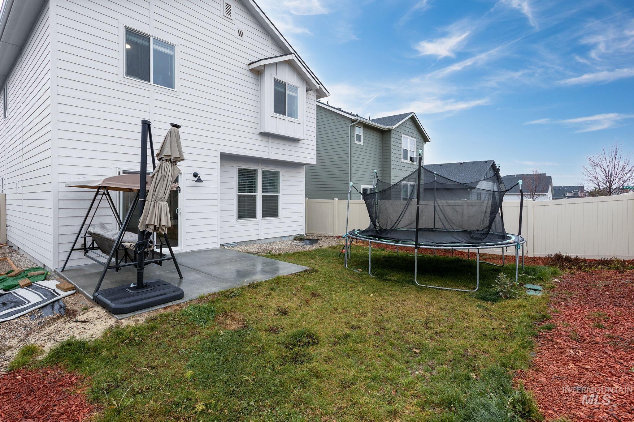 262 South Riggs Spg Avenue Meridian, ID 83642 - Photo 23 of 25 Back of house with a patio area, a fenced backyard, and a trampoline
