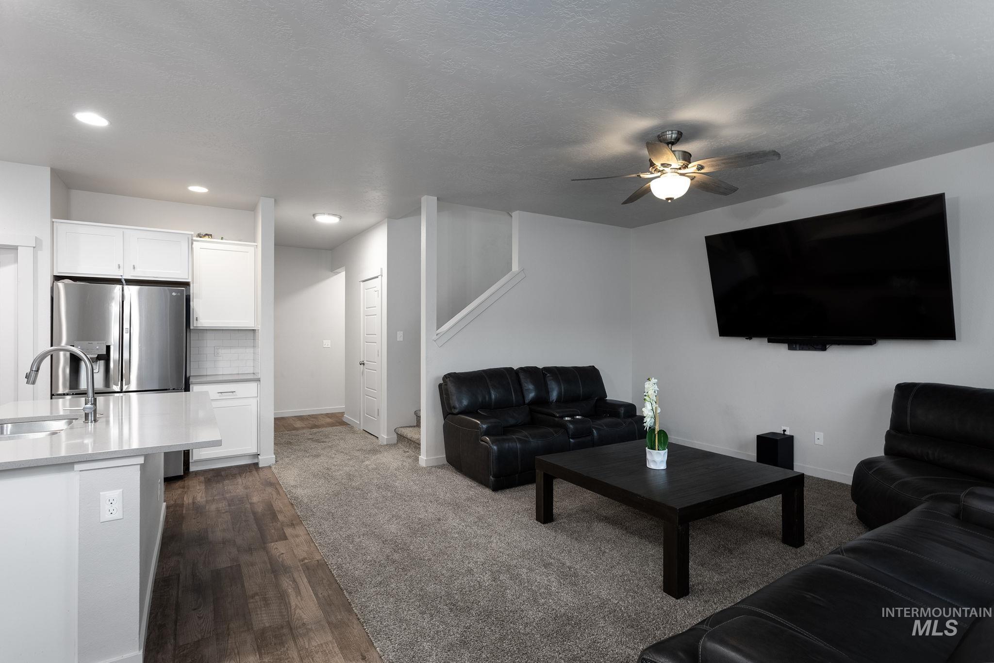 262 South Riggs Spg Avenue Meridian, ID 83642 - Photo 6 of 25 Living area featuring dark wood-type flooring, a ceiling fan, and a textured ceiling