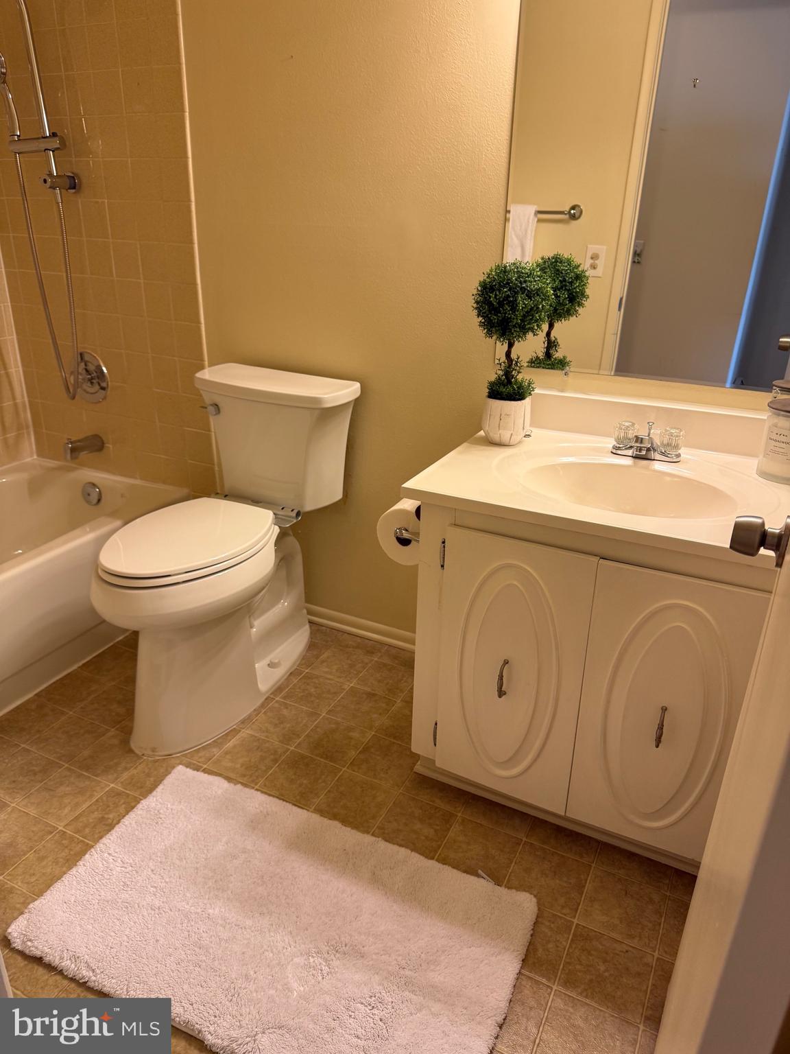 15401 Bassett Lane, Unit 452E Silver Spring, MD 20906 - Photo 27 of 31 a bathroom with a toilet sink and mirror