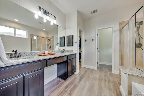 a spacious bathroom with a double vanity sink a mirror and a bathtub