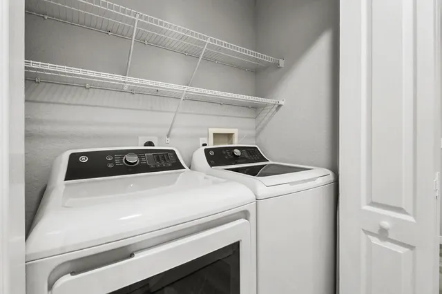 a close up view of washer and dryer with bathroom in the background