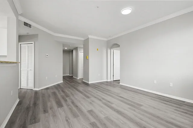 a view of an empty room with wooden floor