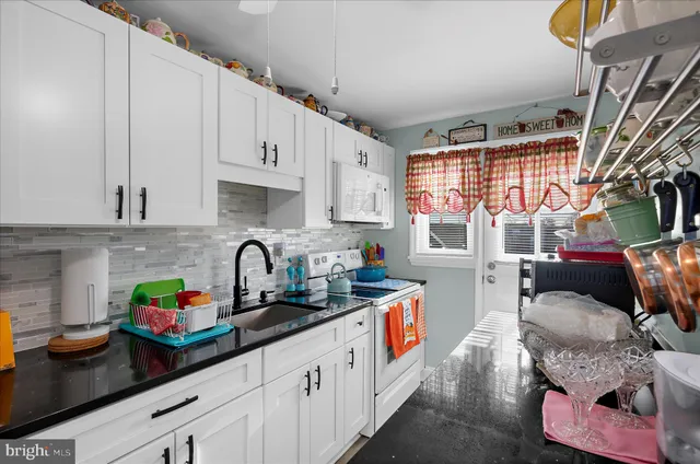a kitchen with stainless steel appliances granite countertop a sink dishwasher and cabinets with wooden floor