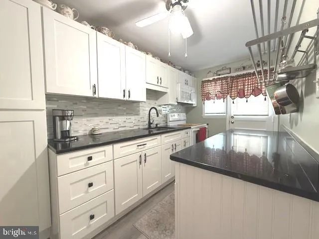 a kitchen with stainless steel appliances granite countertop a sink a stove and cabinets