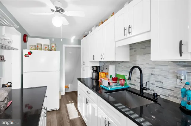 a kitchen with stainless steel appliances a sink a refrigerator a counter space and cabinets