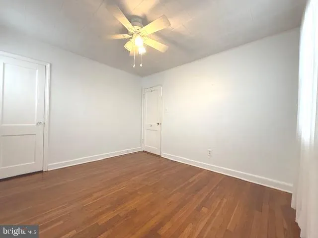 an empty room with wooden floor and window