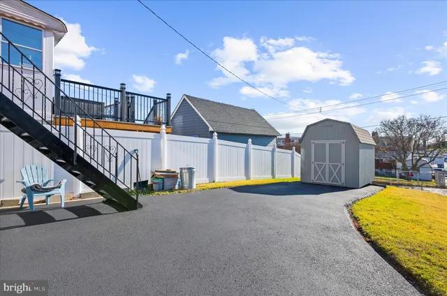 a view of pool with lawn chairs and wooden fence