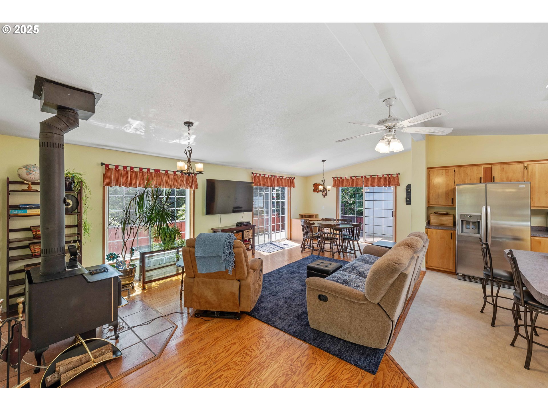 1615 Kristi Loop Lakeside, OR 97449 - Photo 27 of 38 a living room with furniture a flat screen tv and a large window