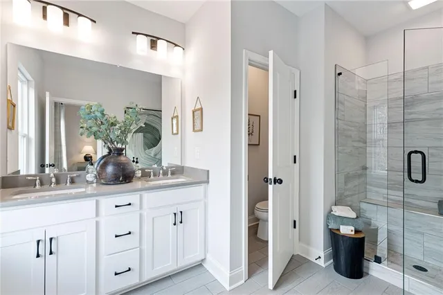 a bathroom with a granite countertop sink a mirror a vanity and a shower