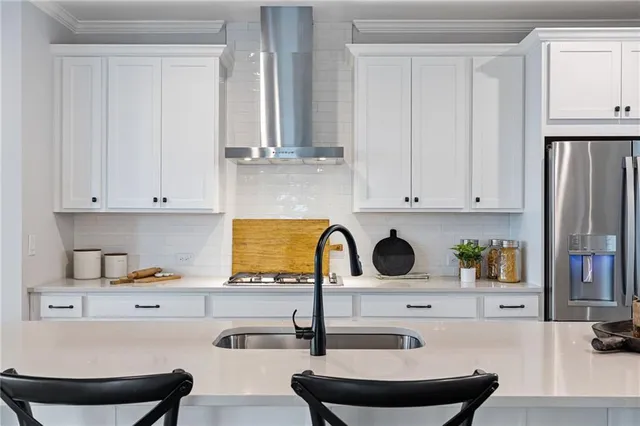 a kitchen with stainless steel appliances kitchen island granite countertop a sink and white cabinets