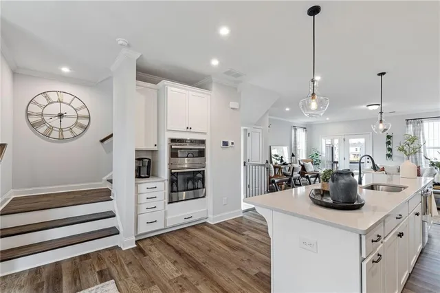 a kitchen with stainless steel appliances a table chairs and a chandelier