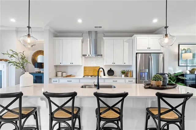 a kitchen with stainless steel appliances kitchen island granite countertop a dining table chairs sink and microwave