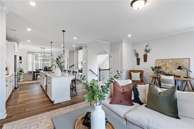 a living room with furniture kitchen view and a chandelier
