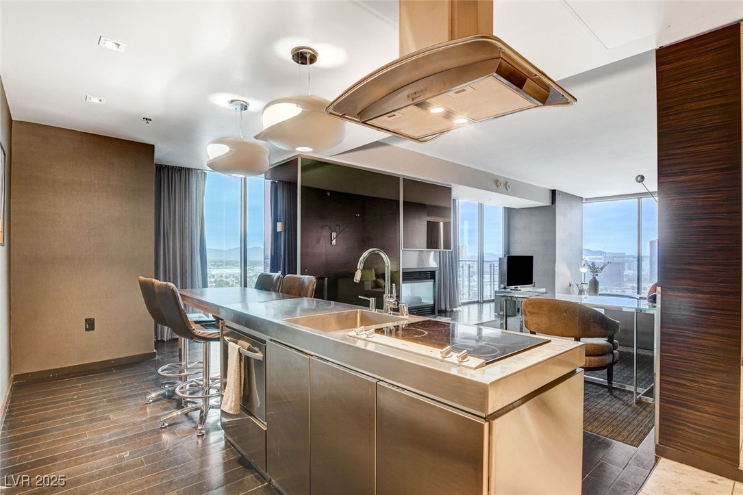 4381 West Flamingo Road, Unit 2202 Las Vegas, NV 89103 - Photo 15 of 40 Kitchen with floor to ceiling windows, island exhaust hood, dark wood-style floors, an island with sink, and dishwasher