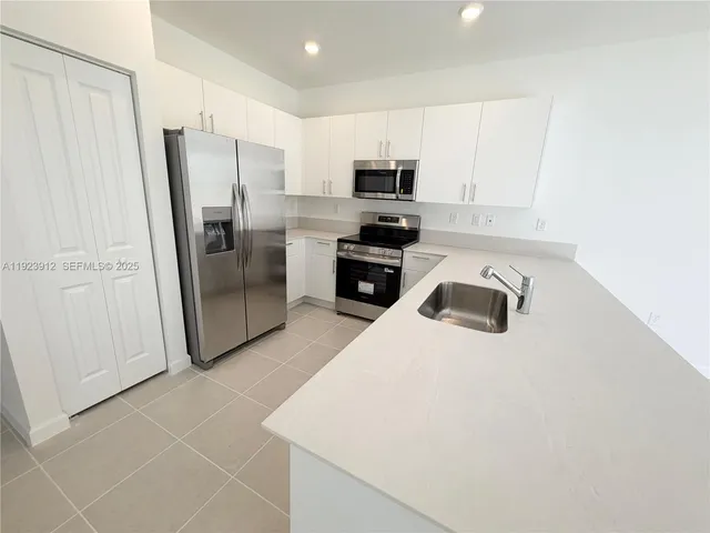 a kitchen with a sink a window and stainless steel appliances