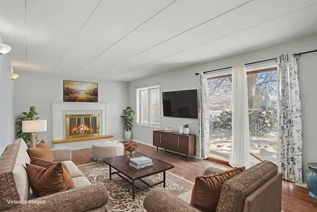 a living room with furniture a flat screen tv and a fireplace