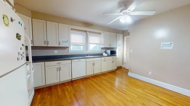 a kitchen with granite countertop white cabinets and white appliances