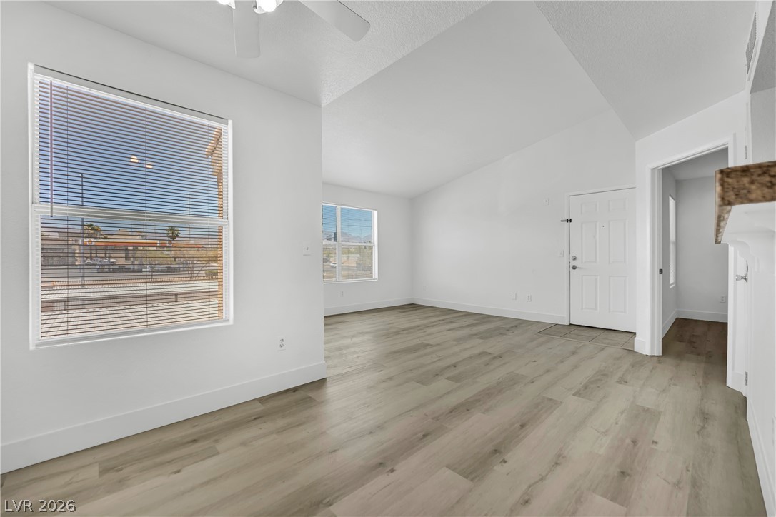 8101 West Flamingo Road, Unit 2030 Las Vegas, NV 89147 - Photo 17 of 27 A pristine, well-lit living space with wood-look flooring and an inviting entry.