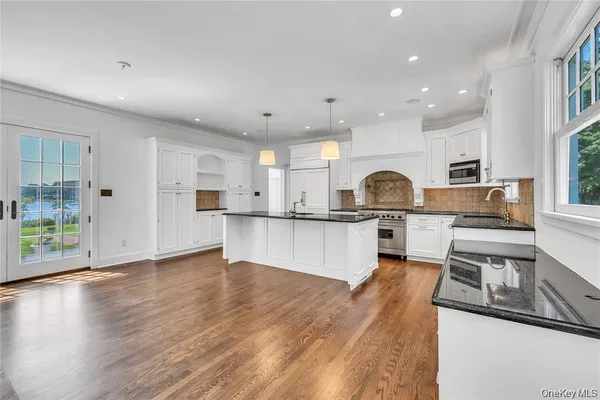 a open kitchen with kitchen island white cabinets and stainless steel appliances
