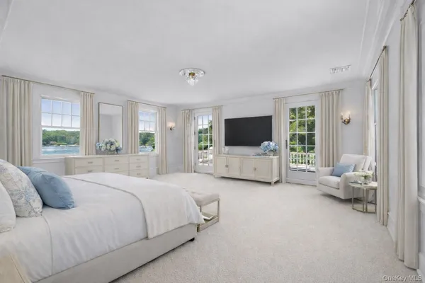 a spacious bedroom with a bed and a flat screen tv