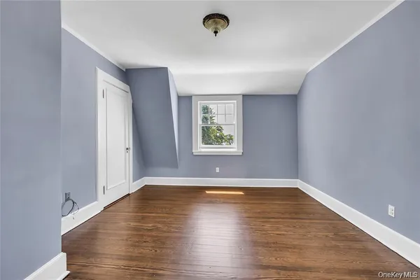 a view of a room with wooden floor and window