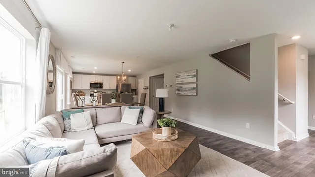 a living room with furniture and a view of kitchen