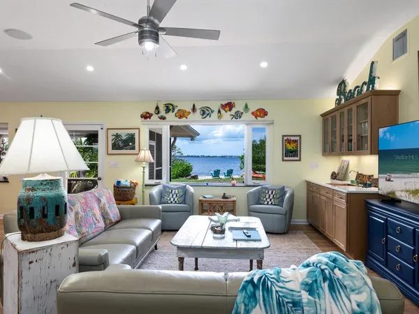 a living room with furniture kitchen view and a wooden floor